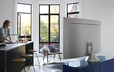 그래비티 스탠드가 장착된 제품의 뒷면이 보여지고 제품의 앞쪽에는 바 테이블에서 손을 닦고 있는 여성의 모습이 보여지고 있습니다.