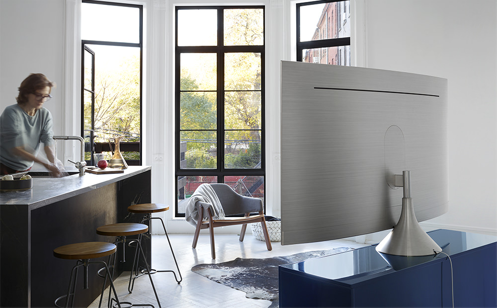 그래비티 스탠드가 장착된 제품의 뒷면이 보여지고 제품의 앞쪽에는 바 테이블에서 손을 닦고 있는 여성의 모습이 보여지고 있습니다.