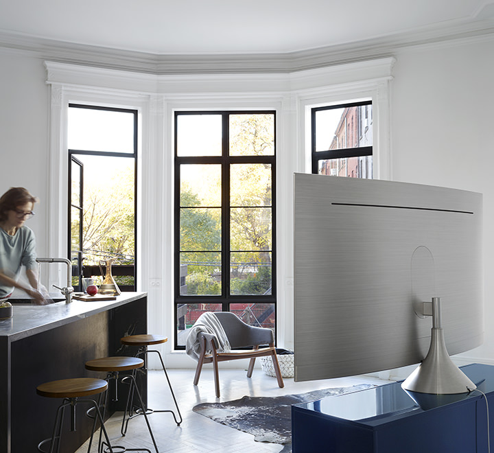 그래비티 스탠드가 장착된 제품의 뒷면이 보여지고 제품의 앞쪽에는 바 테이블에서 손을 닦고 있는 여성의 모습이 보여지고 있습니다.